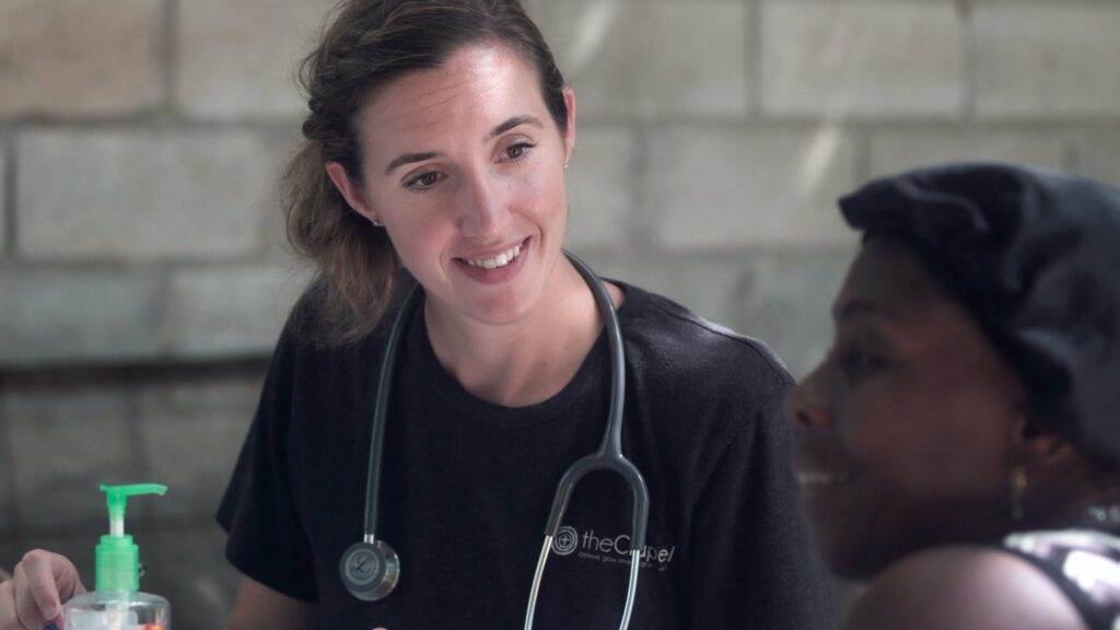 nurse in black crew neck shirt wearing blue earbuds